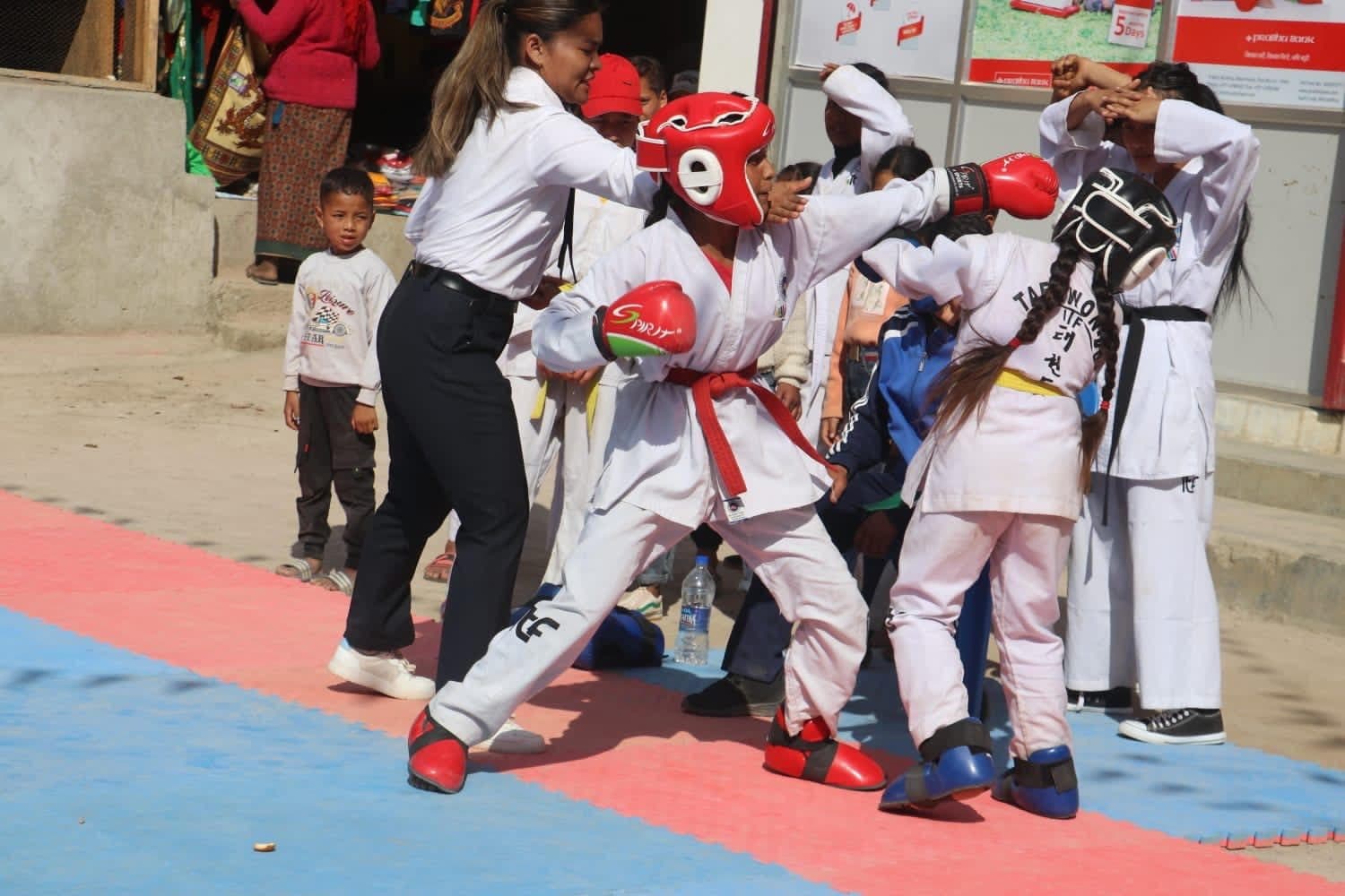Two competitors sparring on open-air mats at the Nisikhola tournament